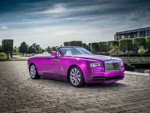 Magentafärgad Rolls-Royce cabriolet på en kullerstensgård