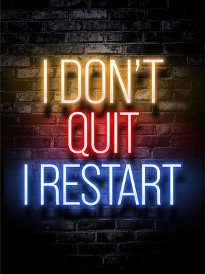 Neontext I don't quit I restart i gult, rött och blått